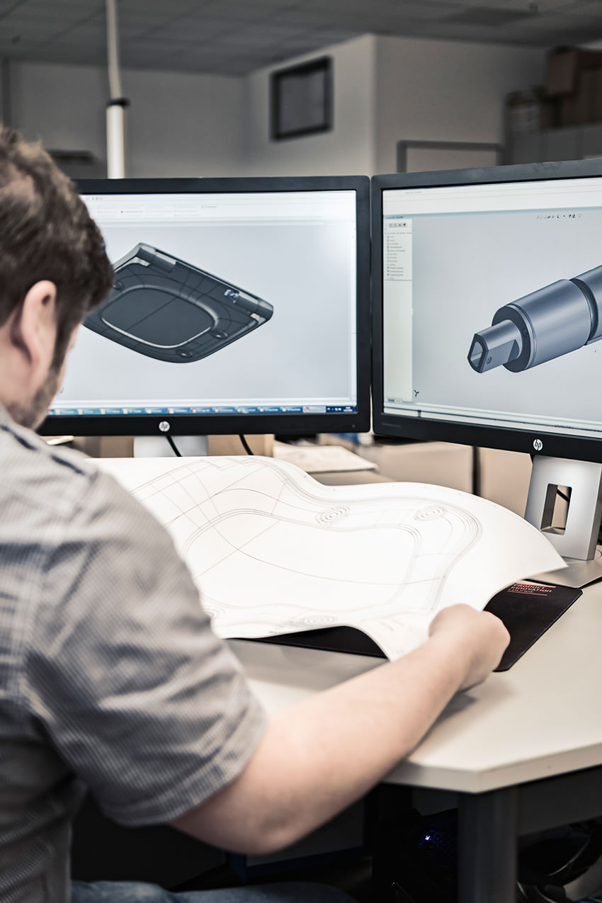 Staff member designing a toilet seat on a computer with the help of a 3D model.